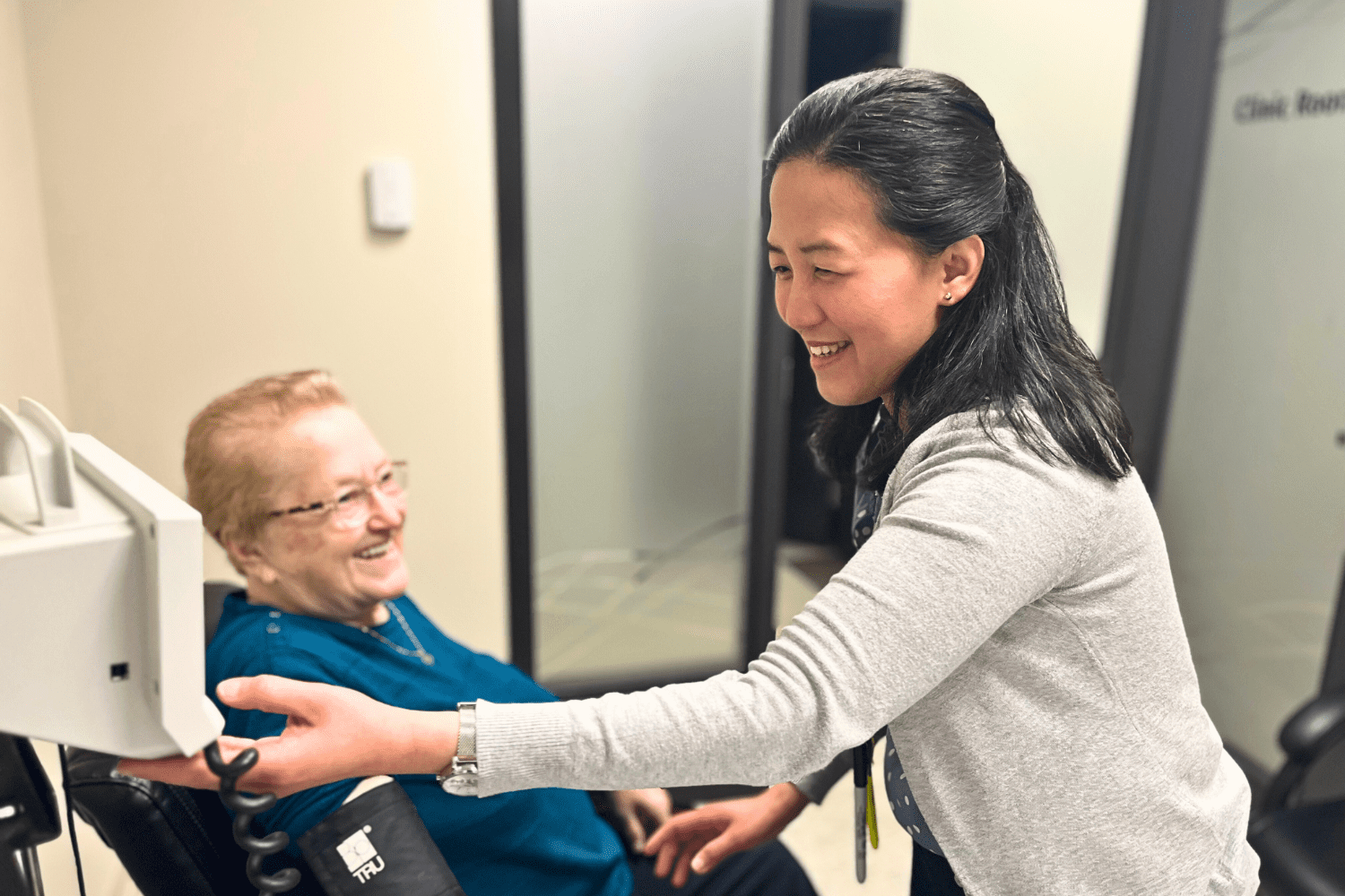 pharmacy assistant taking a senior patient's blood pressure in the private clinical consulting room